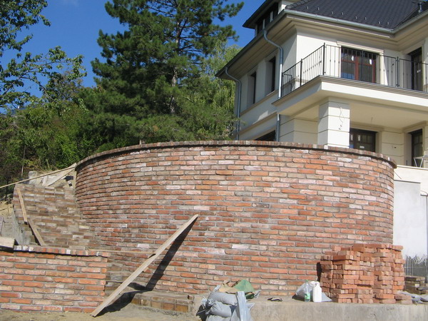 Klasszikus villa őszi kertje panorámás kilátással, formára nyírt bukszusokkal és vadszőlővel