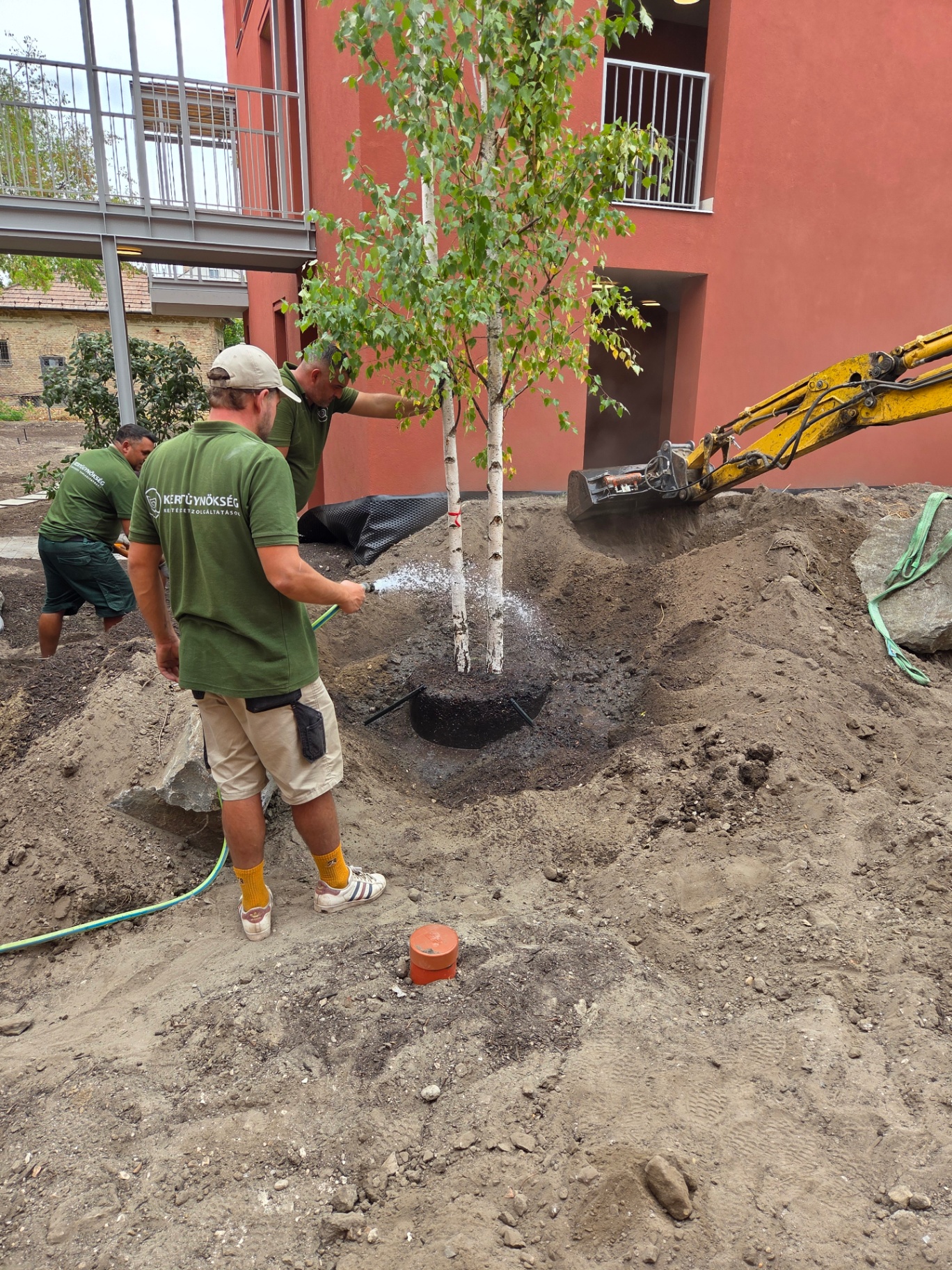Sziklakertes társasházi udvar beültetéssel és nagy kövekkel